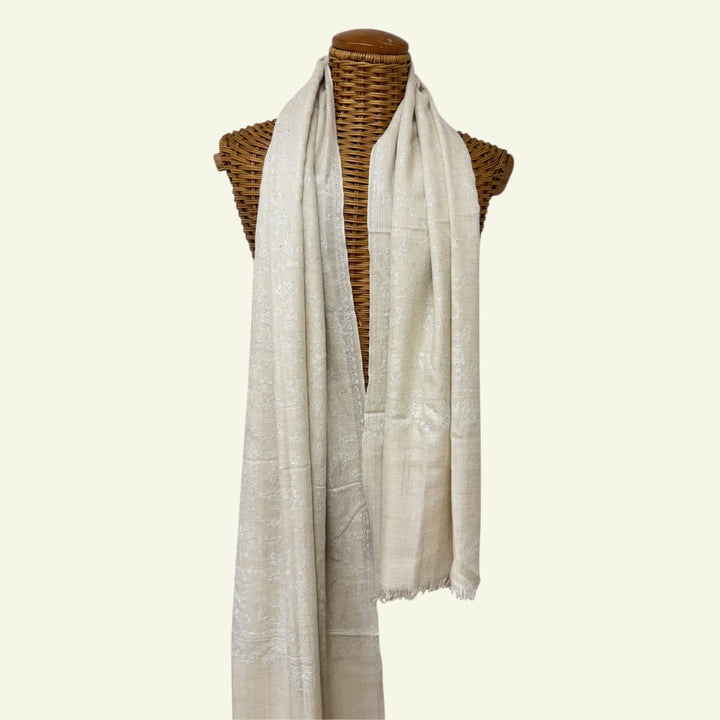 White scarf draped over a mannequin on a white background