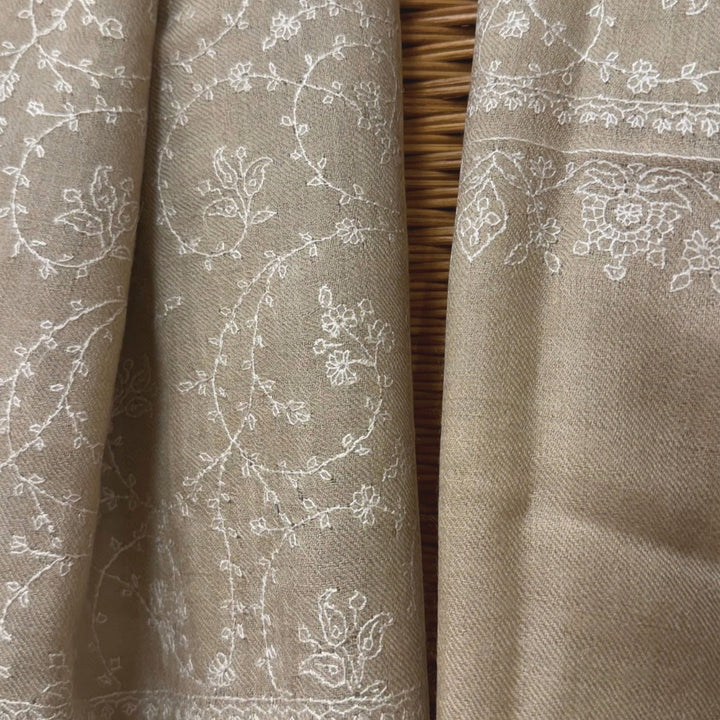 Beige Pashmina with white floral embroidery, draped on maniquine