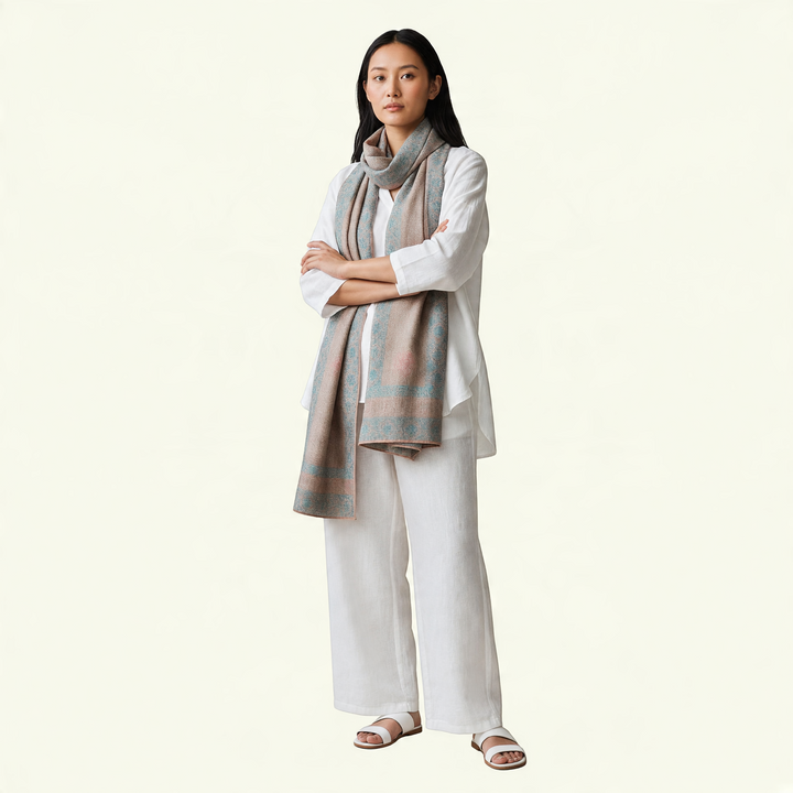 Model wearing an Indus Weavers undyed taupe Pashmina shawl with delicate pink and blue floral Sozni embroidery.