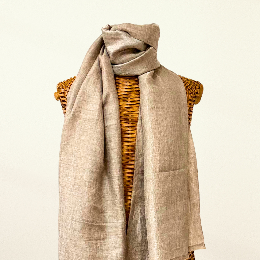 Beige pashmina scarf draped over a woven mannequin on a Taupe background