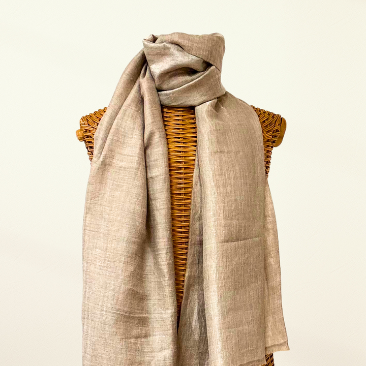 Beige pashmina scarf draped over a woven mannequin on a Taupe background