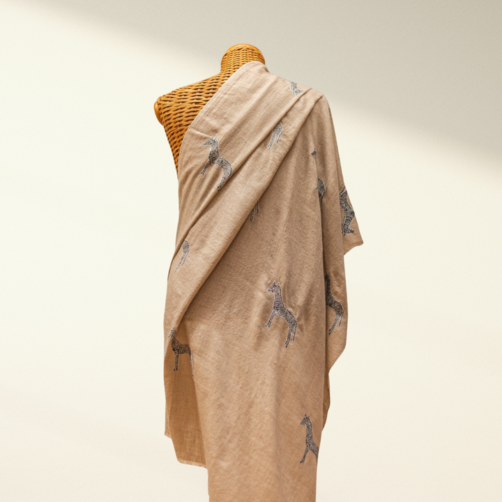 Beige pashmina shawl with zebra patterns draped over a mannequin against a neutral background