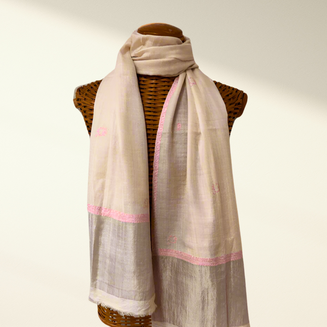 Beige pashmina scarf with pink trim draped over a mannequin on a white background