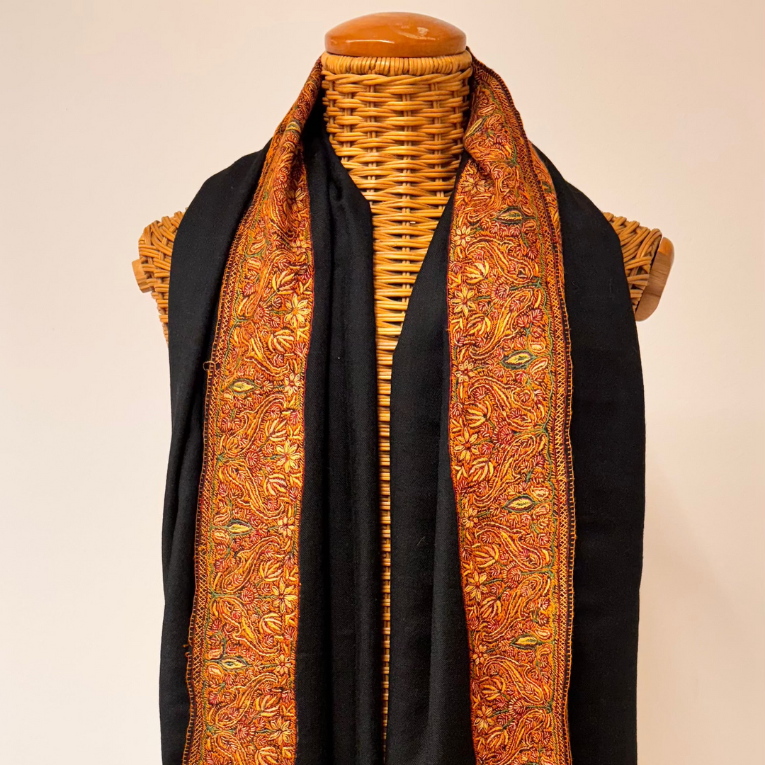 Black cashmere shawl with traditional Sozni embroidery in brown and orange tones.
