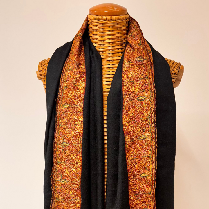 Black cashmere shawl with traditional Sozni embroidery in brown and orange tones.