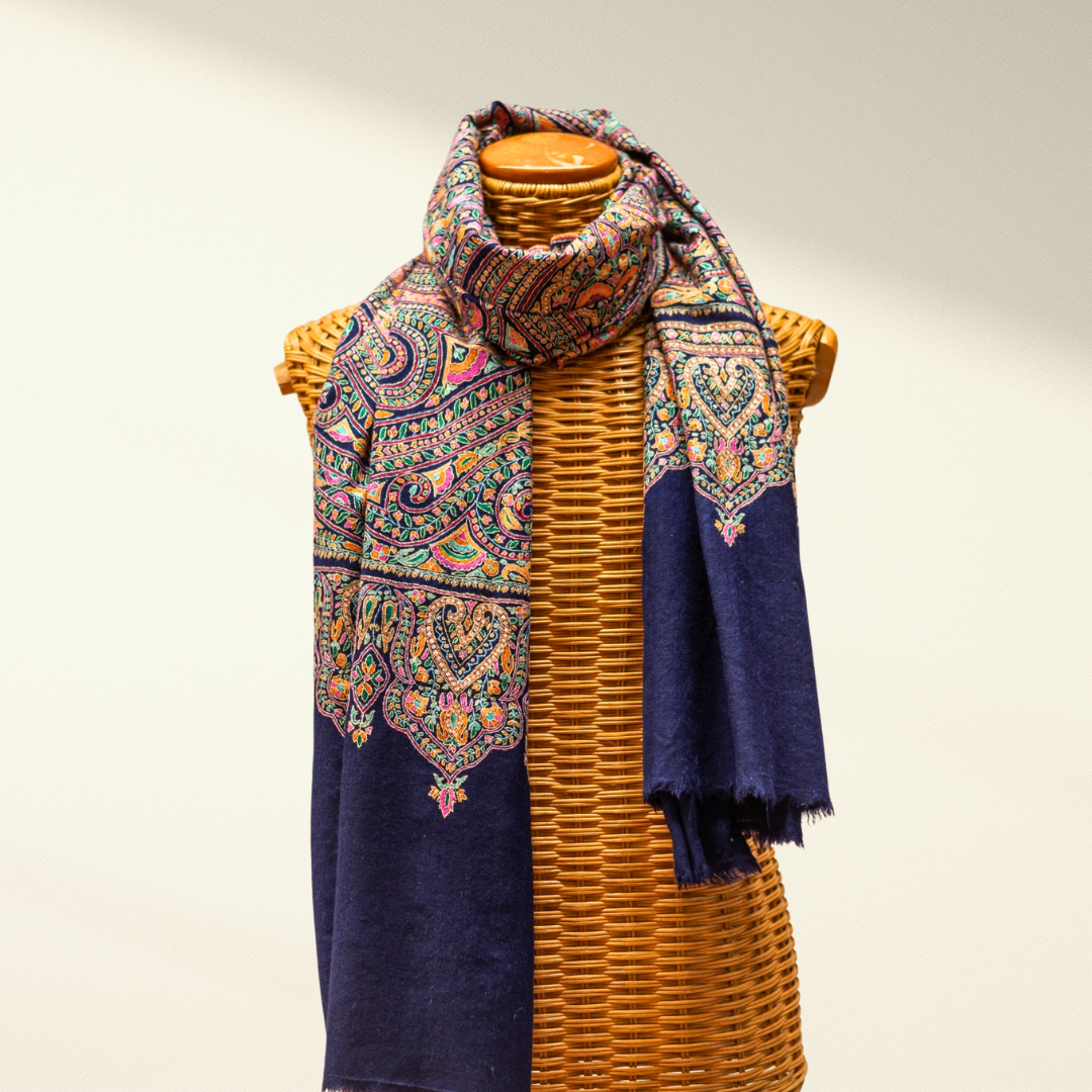 Blue jamawar pashmina scarf draped over a wicker mannequin on a neutral background