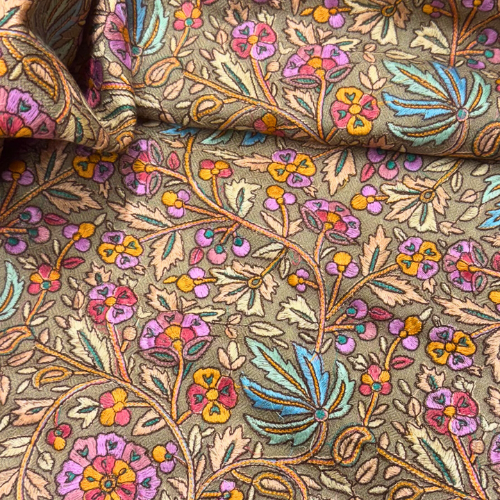 Close-up of floral patterned pashmina with multicolor design on a beige background