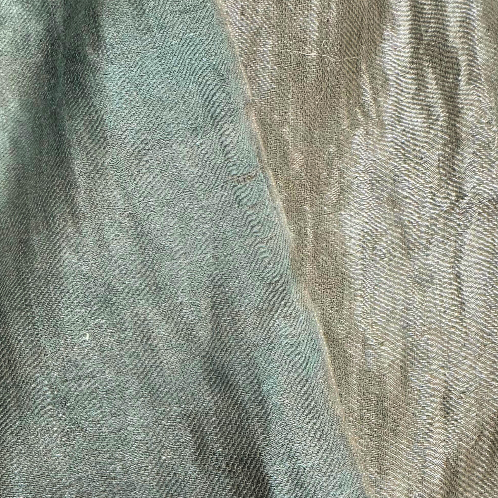 Close-up of metallic pashmina shawl with a gradient from green to silver