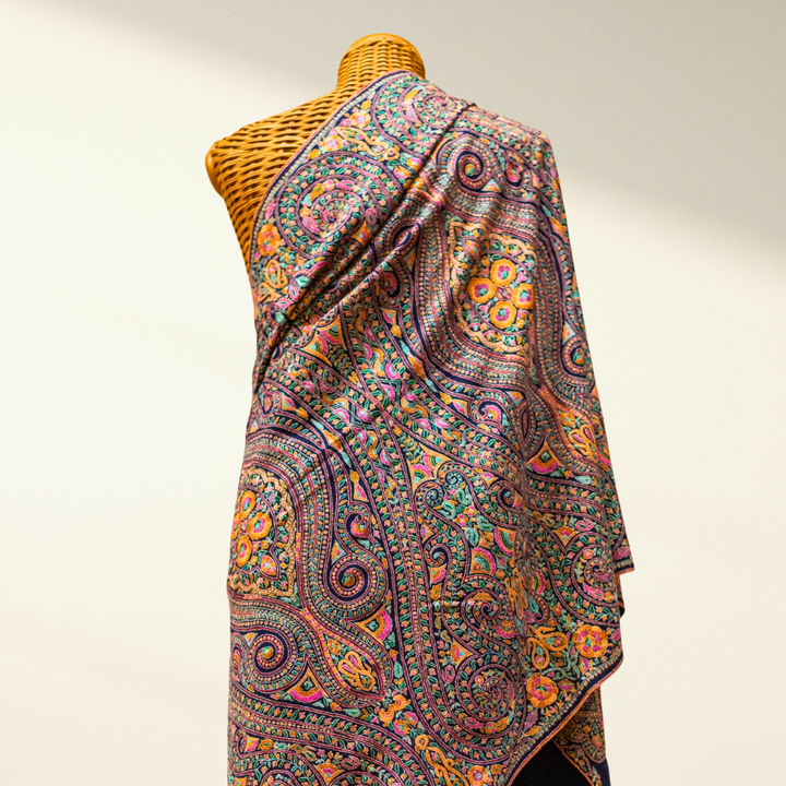 Colorful Jamawar pashmina shawl on a mannequin against a plain background
