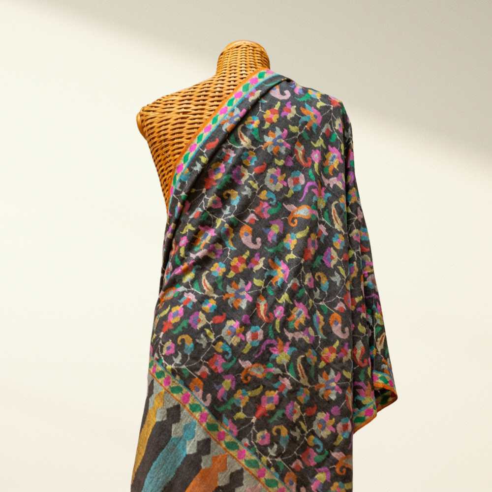 Colorful patterned Kani Pashmina draped over a mannequin against a plain background