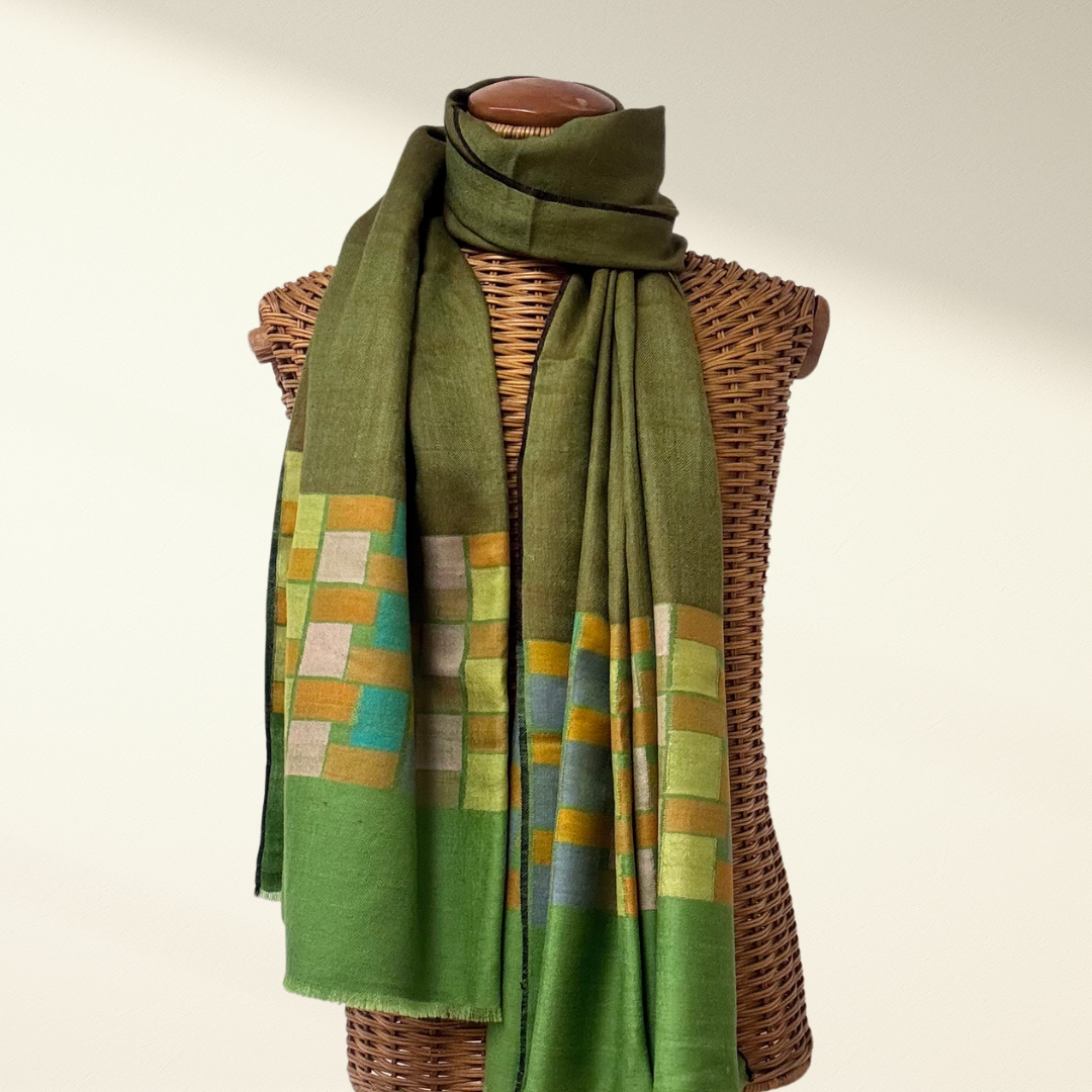 Green Pashmina Shawl Cubic with a geometric pattern draped over a wicker mannequin on a white background