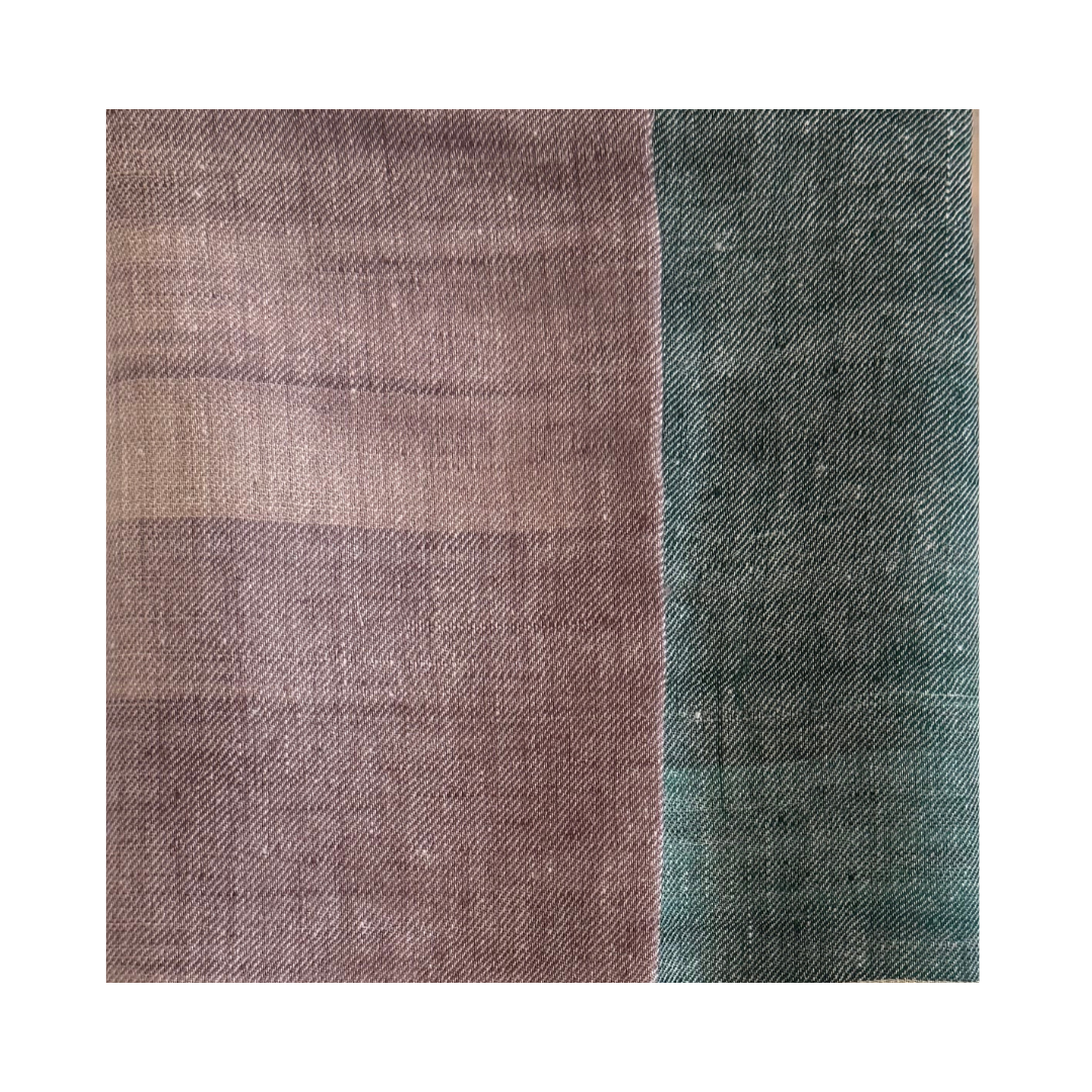 Close-up of a handwoven Pashmina foulard featuring a soft ivory base with muted mauve and deep teal tones, connected through a delicate Ikat-transition that highlights the fine weave and artisanal texture.