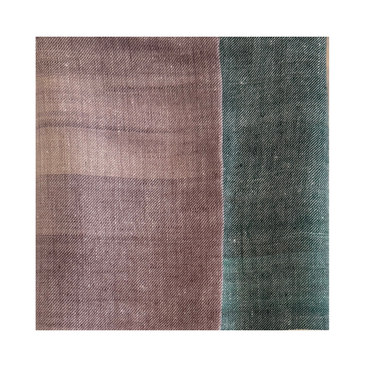 Close-up of a handwoven Pashmina foulard featuring a soft ivory base with muted mauve and deep teal tones, connected through a delicate Ikat-transition that highlights the fine weave and artisanal texture.