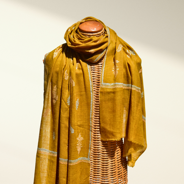 Mustard Pashmina Shawl Ornella draped on a wicker mannequin 