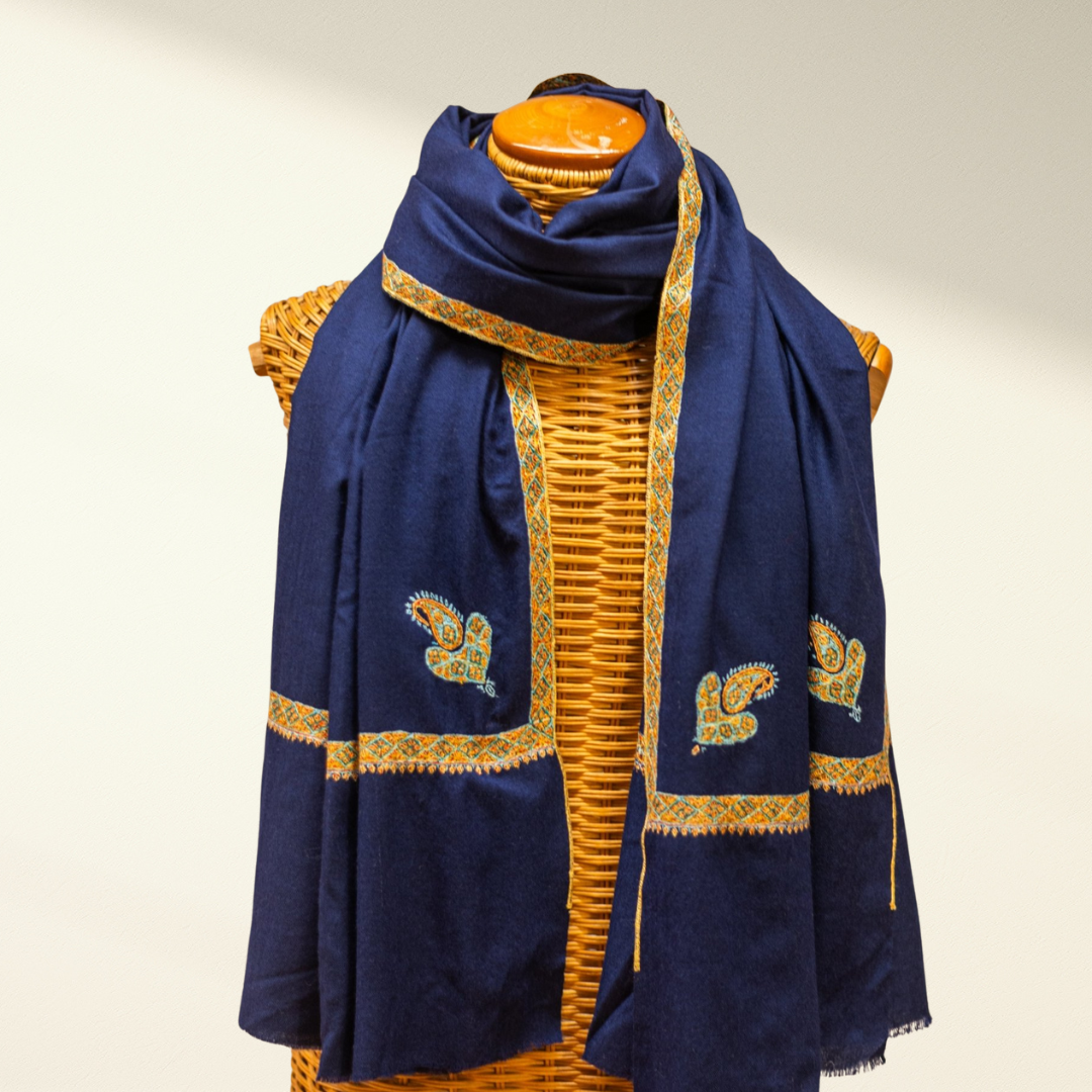 Navy blue pashmina scarf with gold embroidery on a wooden mannequin against a white background