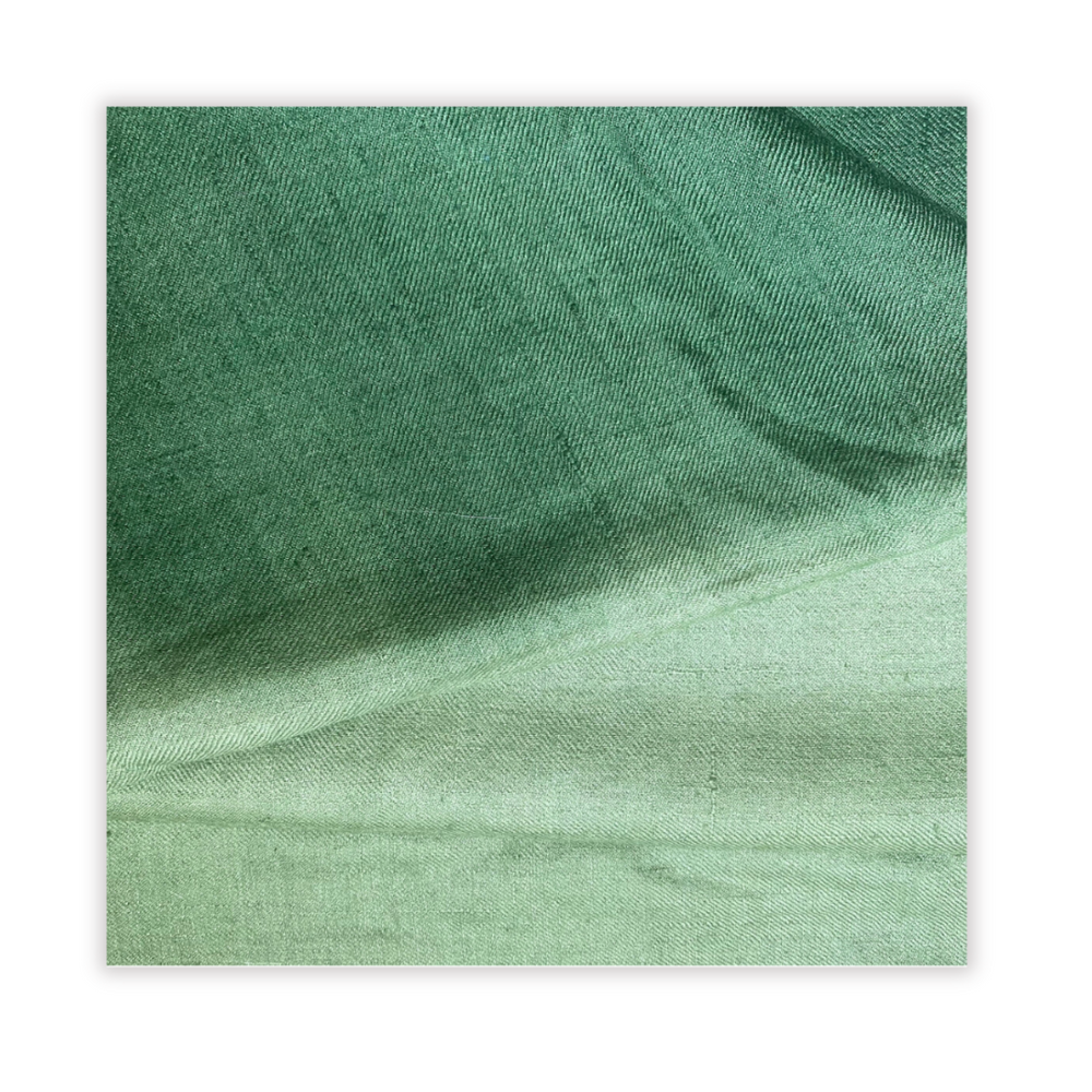 Close-up of green fabric with a subtle pattern on a white background