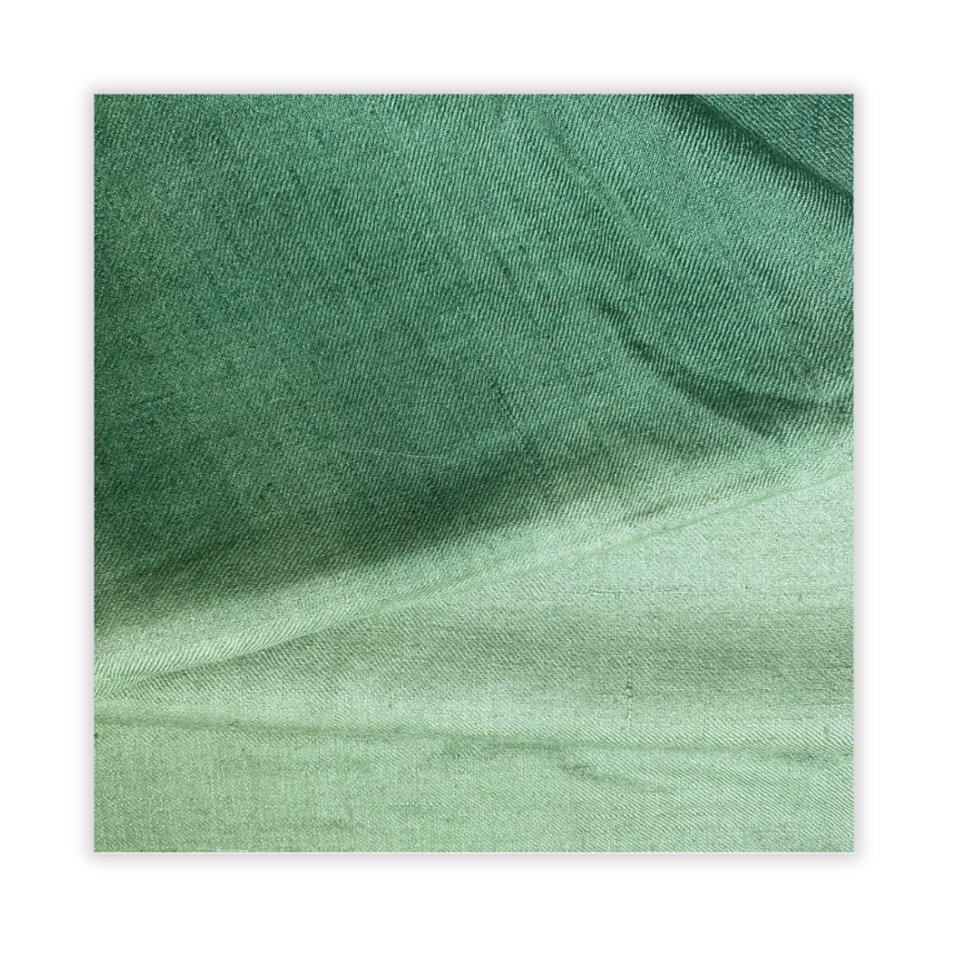 Close-up of green fabric with a subtle pattern on a white background