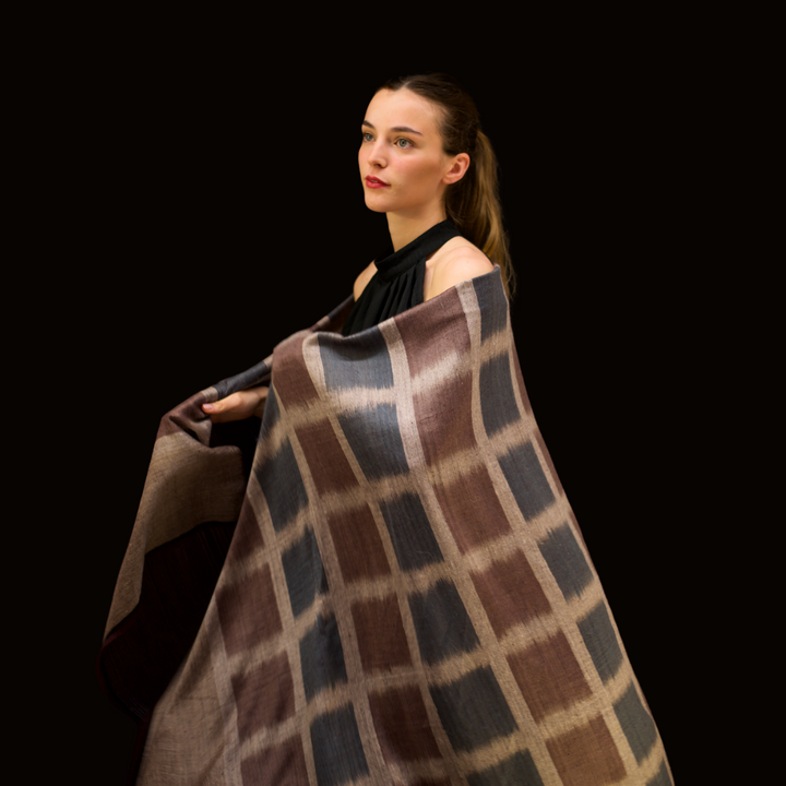 Woman wearing a pashmina shawl against a black background