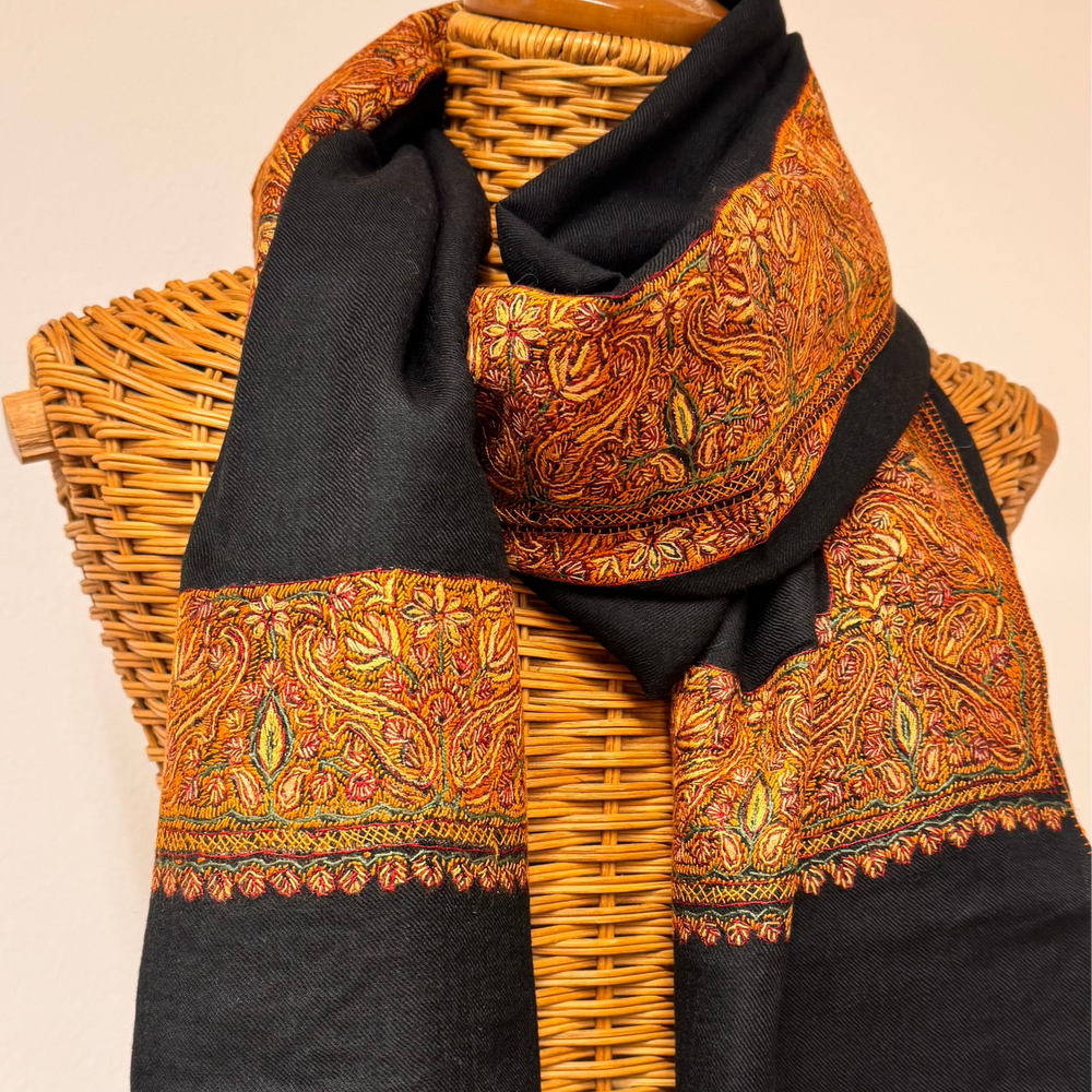 Black cashmere shawl with traditional Sozni embroidery in brown and orange tones.