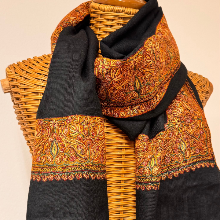 Black cashmere shawl with traditional Sozni embroidery in brown and orange tones.
