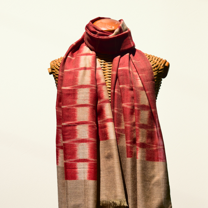 Red and beige plaid pashmina scarf draped over a mannequin on a light background