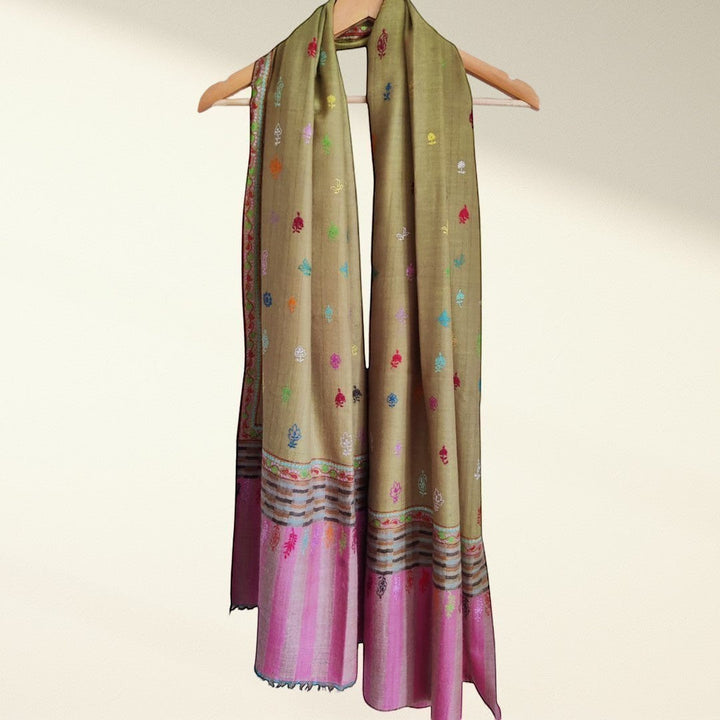 Olive blush scarf with colorful patterns on a hanger against a white background