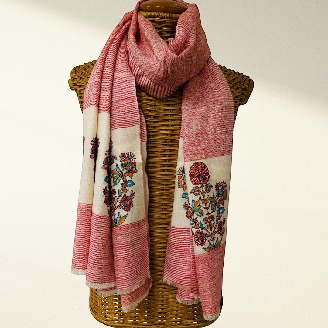 red and white scarf with floral patterns draped over a wicker basket on a light background