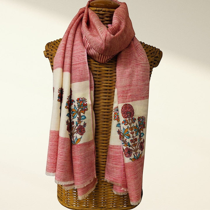 red and white scarf with floral patterns draped over a wicker basket on a light background