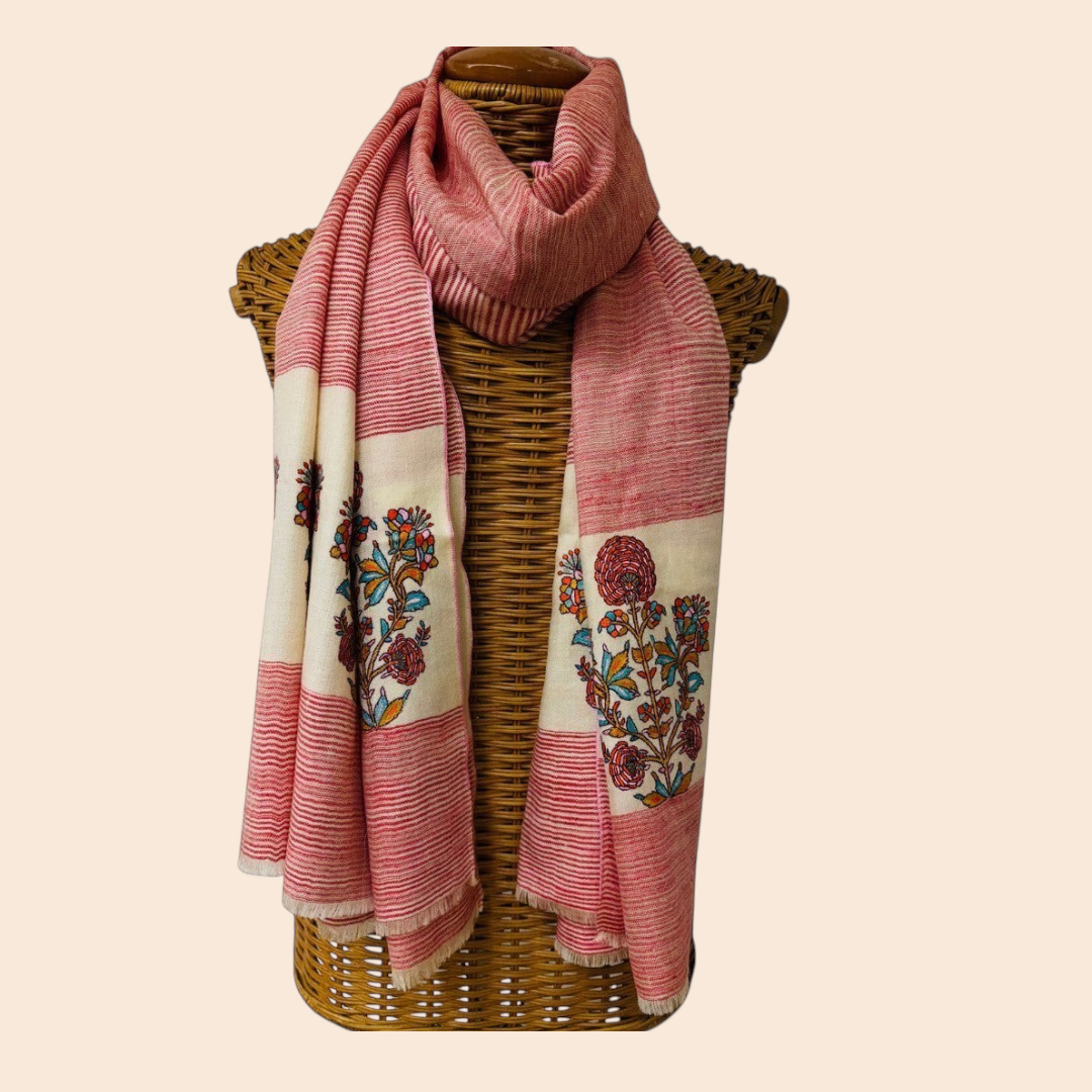 red and white scarf with floral patterns draped over a wicker basket on a light background