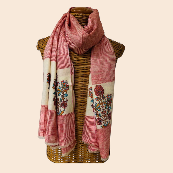 red and white scarf with floral patterns draped over a wicker basket on a light background