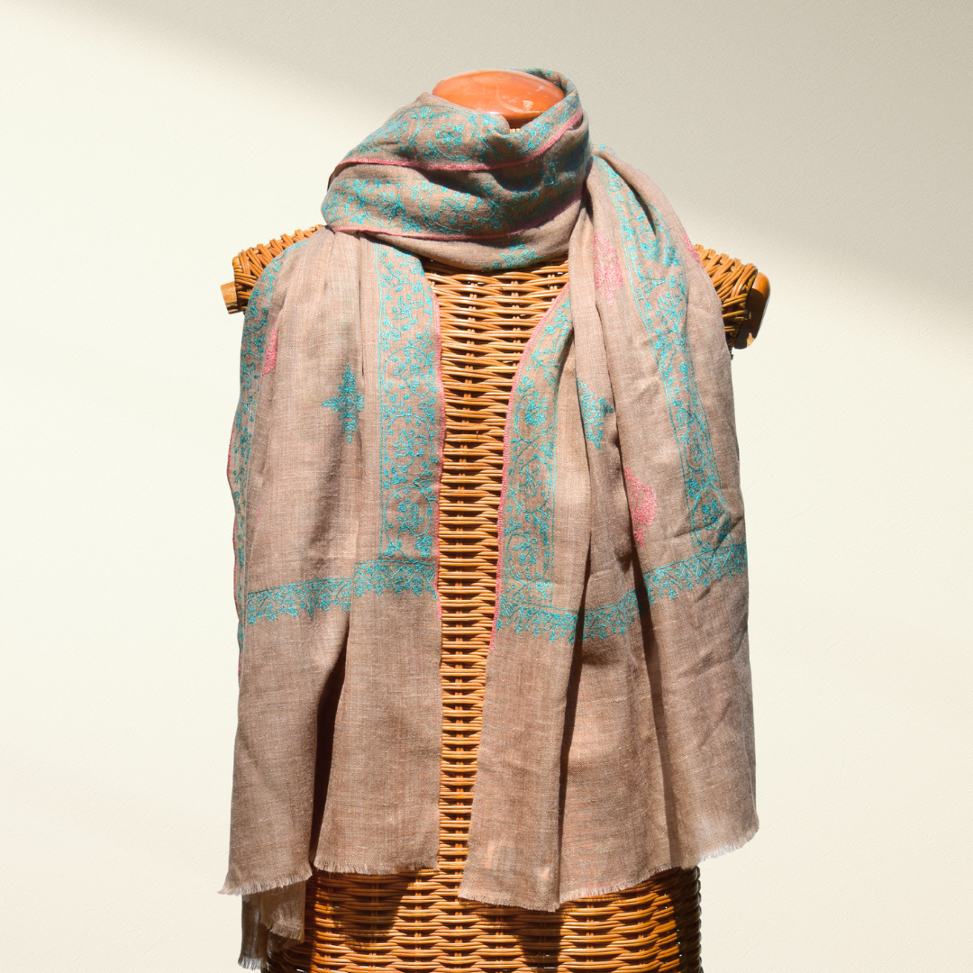 Pure pashmina shawl with a pattern draped over a wicker mannequin on a neutral background