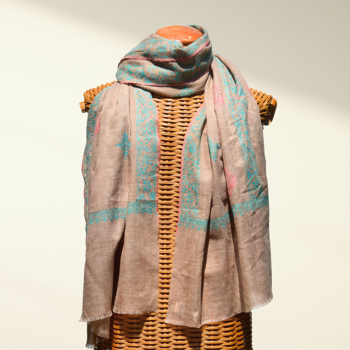 Pure pashmina shawl with a pattern draped over a wicker mannequin on a neutral background