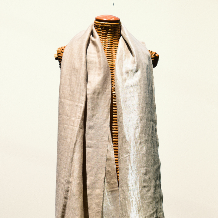 Mannequin wearing a reversible beige pashmina shawl on white background