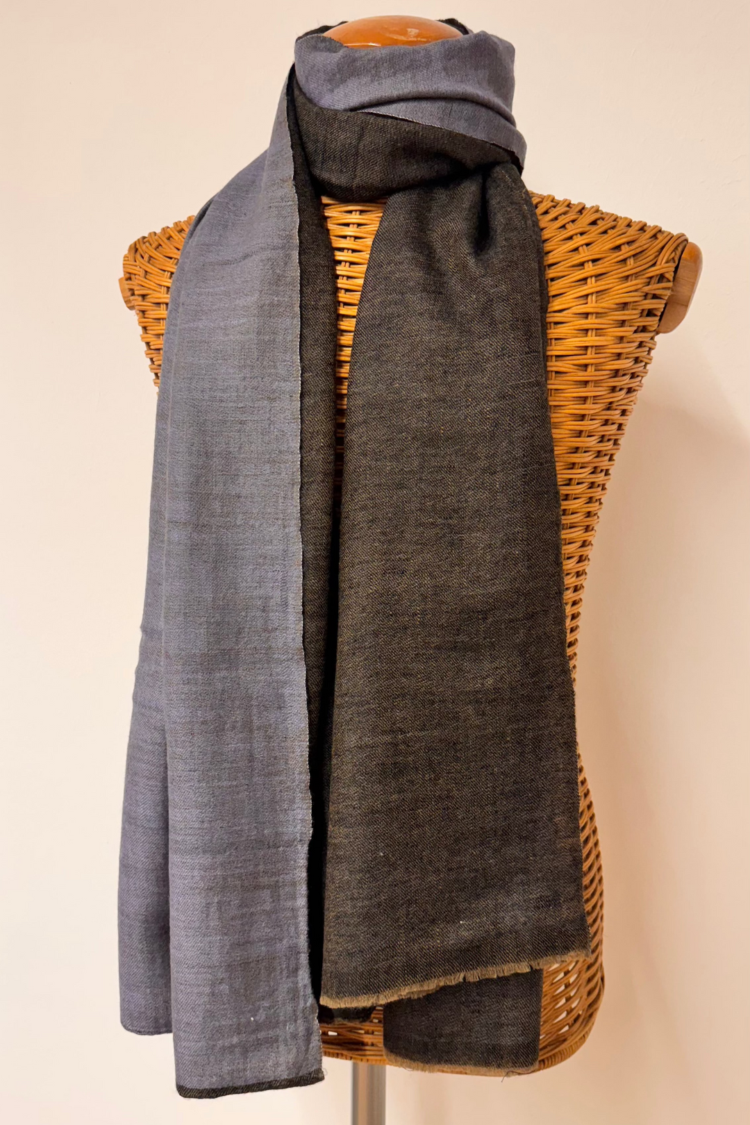reversible pashmina scarf, one side gray and one side dark grey , draped over a mannequin bust against a plain background.
