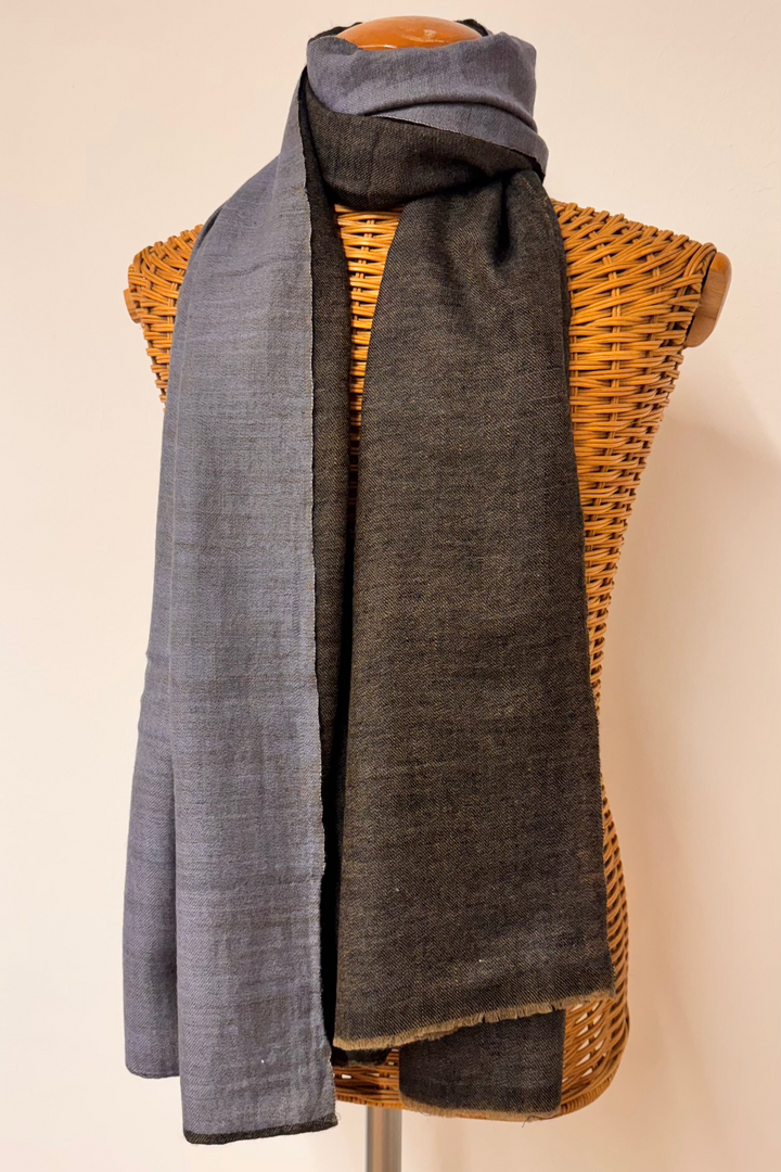 reversible pashmina scarf, one side gray and one side dark grey , draped over a mannequin bust against a plain background.