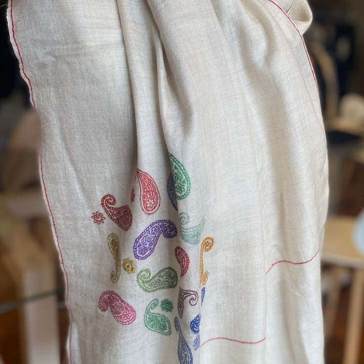 Soft ivory wrap featuring delicate hand-embroidered paisleys.