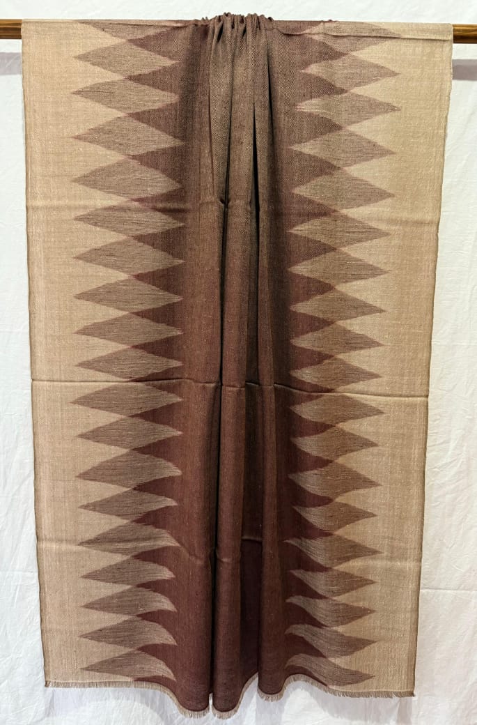 shawl with brown diamond patterns weaved  on a beige background