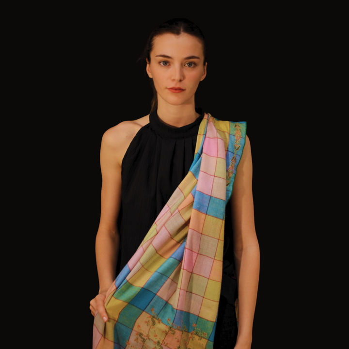 Woman wearing a colorful checkered pashmina scarf on a black background