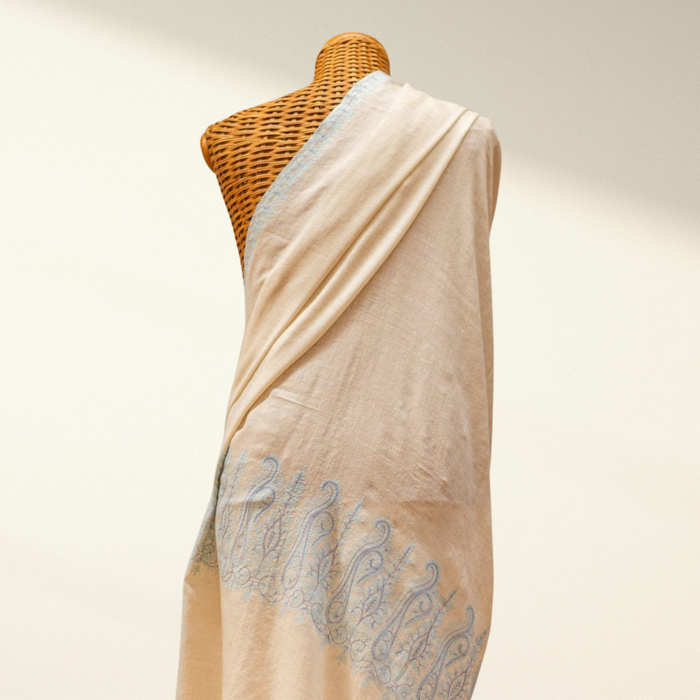 Beige scarf with blue embroidery on a mannequin against a neutral background