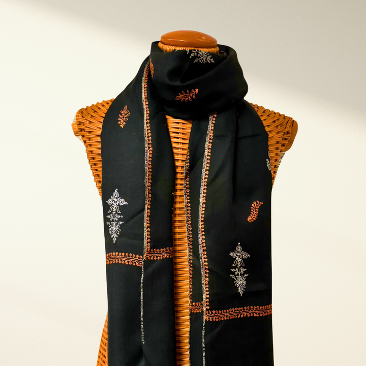 green pashmina scarf with orange and white patterns on a mannequin against a plain background