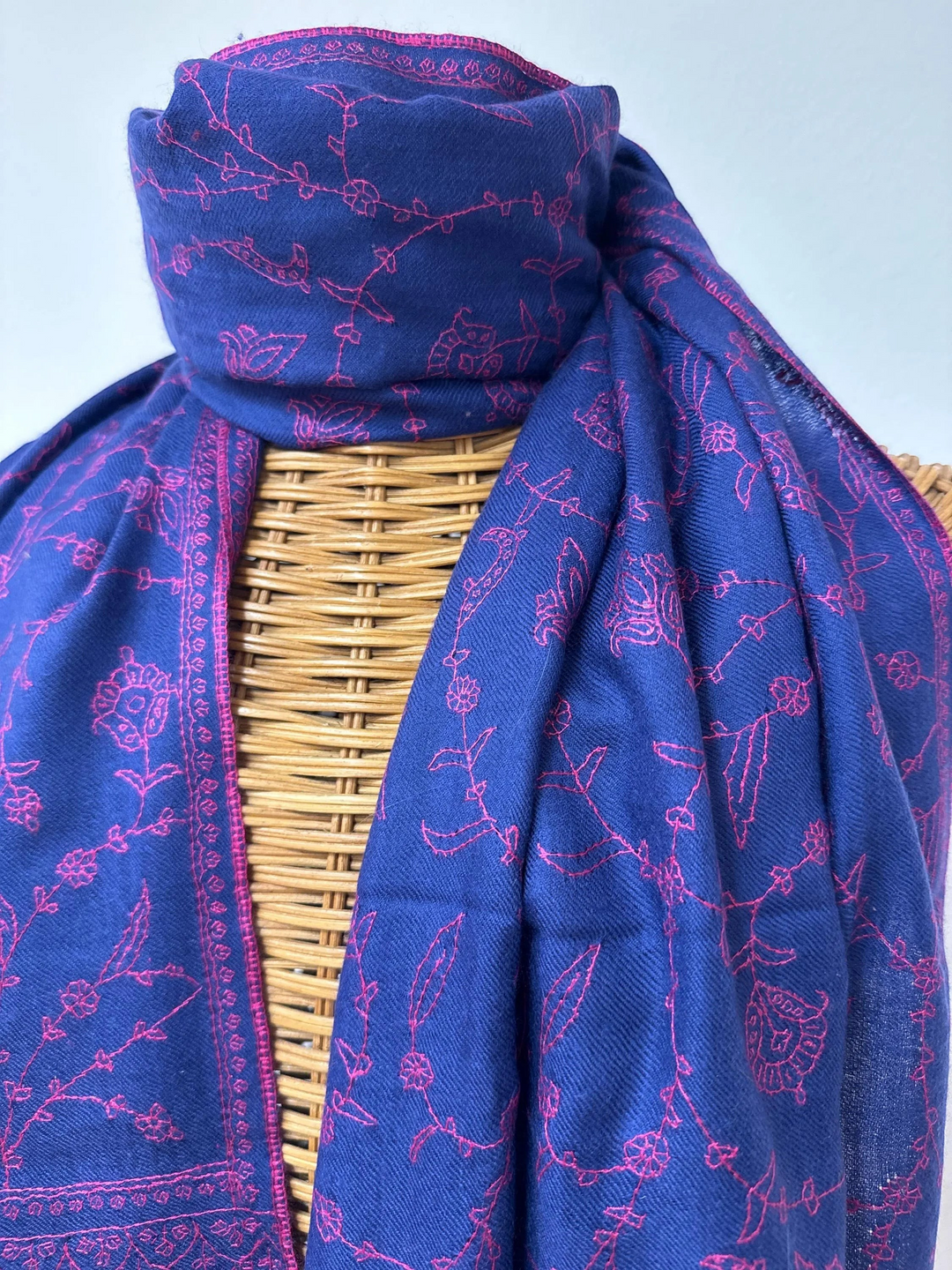 Indus Weavers deep blue pure Pashmina shawl featuring delicate pink floral Sozni hand embroidery and fringed edges.
