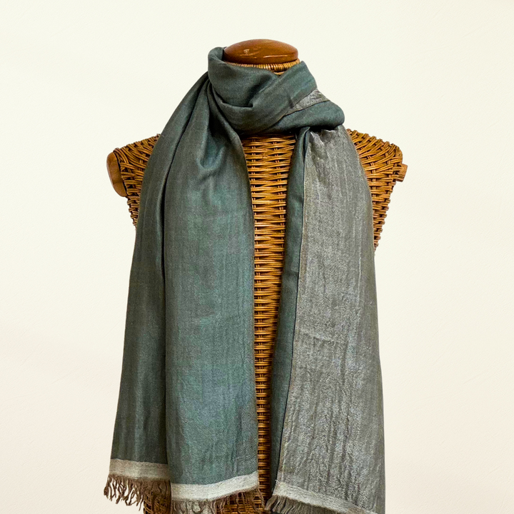 reversible scarf draped over a wicker mannequin with a plain background