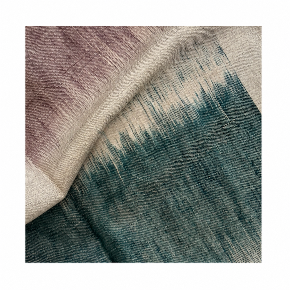 Close-up of a handwoven Pashmina foulard featuring a soft ivory base with muted mauve and deep teal tones, connected through a delicate Ikat-transition that highlights the fine weave and artisanal texture.