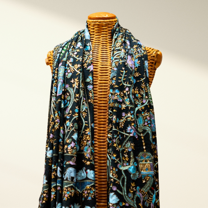 pashmina scarf with floral and animal patterns on a mannequin against a neutral background