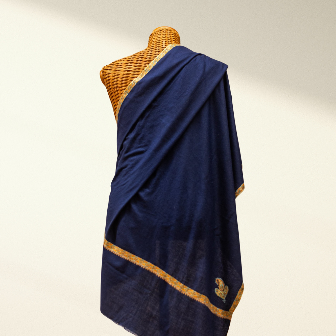 Navy blue pashmina shawl with gold trim draped over a mannequin on a plain background