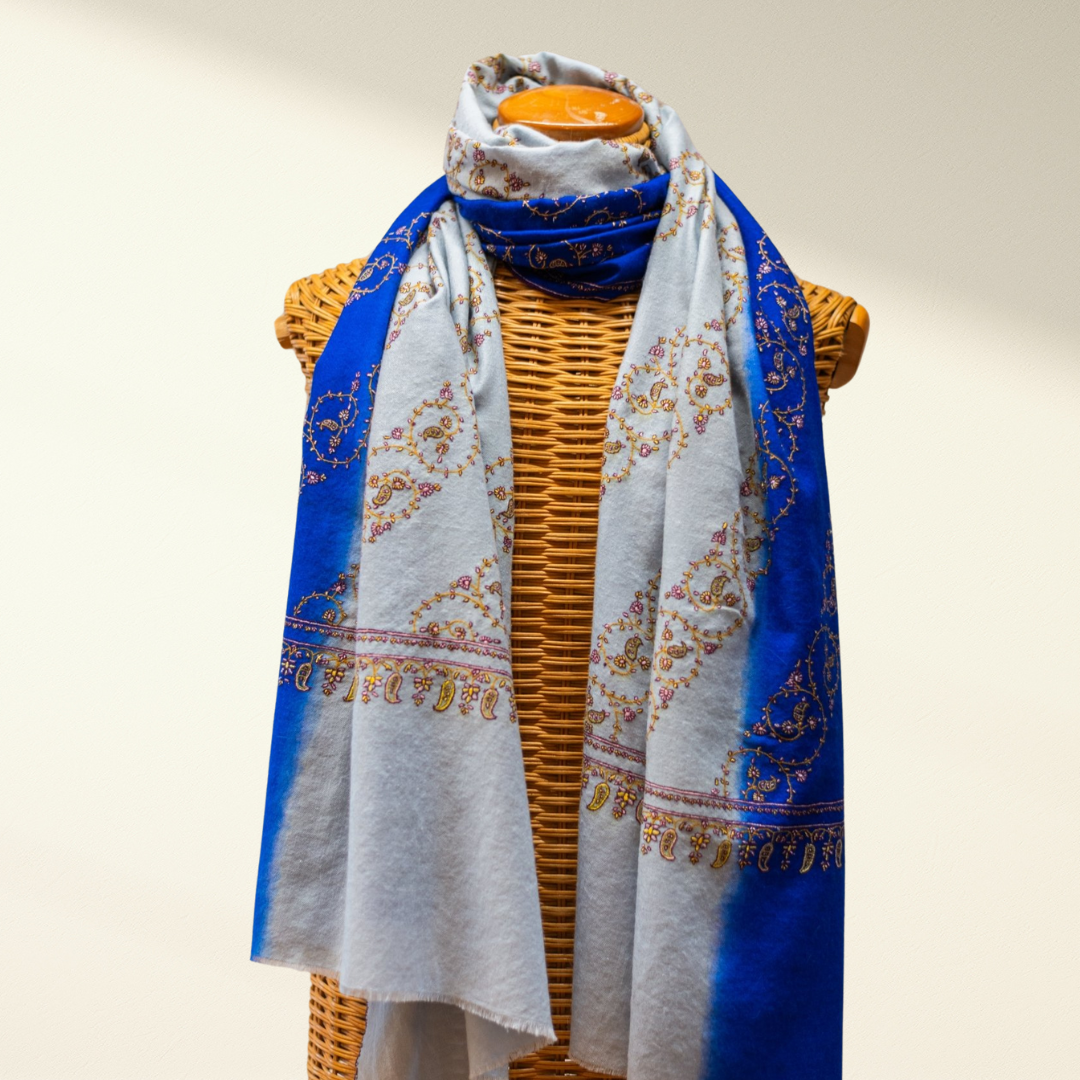 Mannequin wearing a blue and white sozni pashmina with a plain background