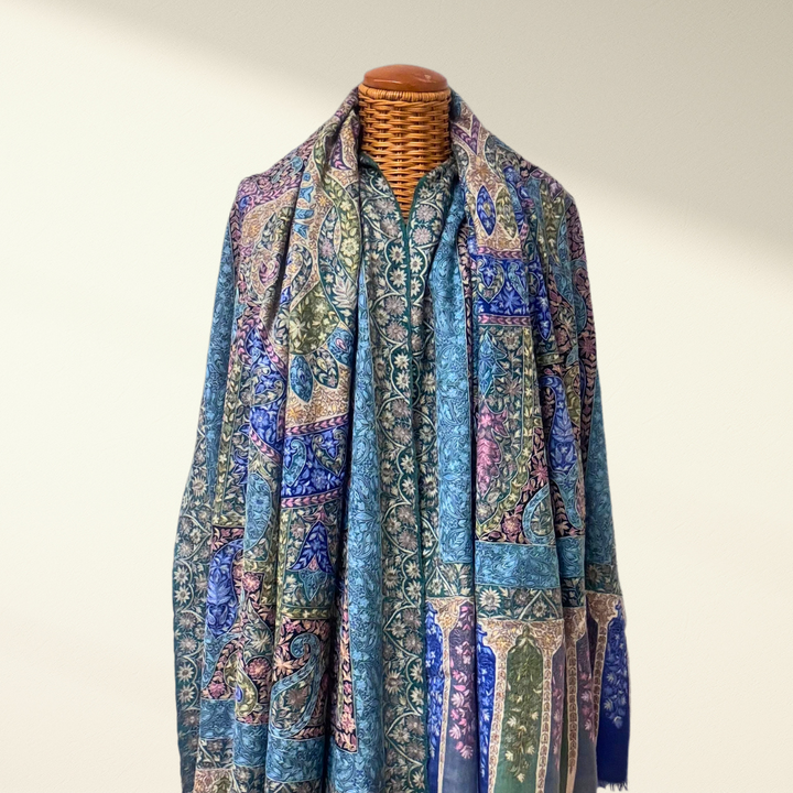 Mannequin wearing a wedding pashmina shawl in blue with embroidery against a plain background